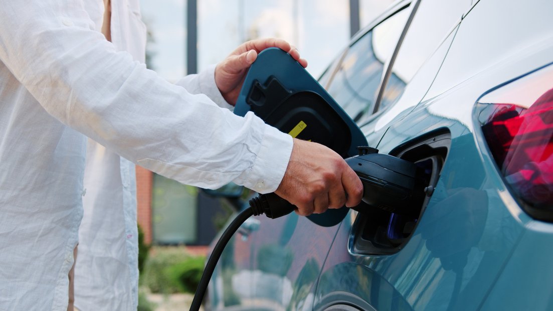 EV charger being plugged in at workplace
